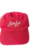 A red baseball cap with 'Latin Lover' embroidered in white script across the front.