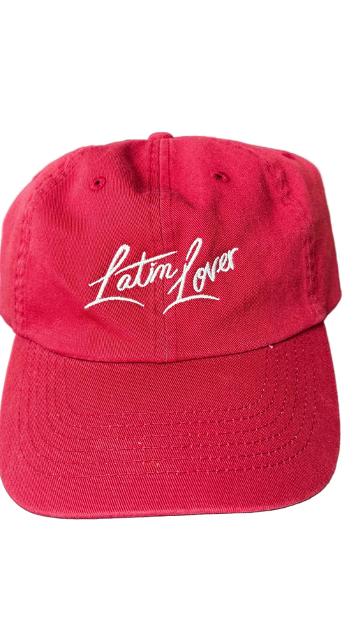 A red baseball cap with 'Latin Lover' embroidered in white script across the front.