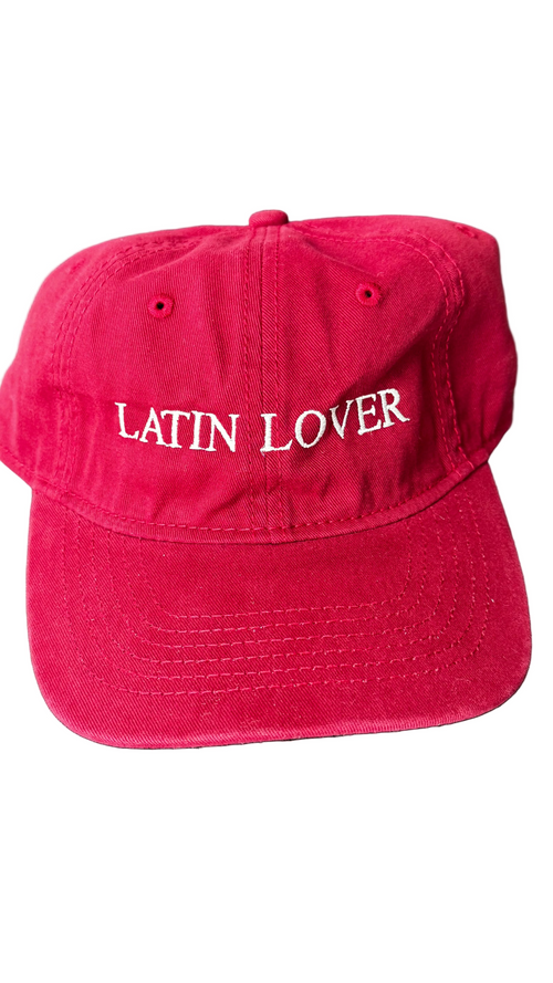 A red baseball cap with 'Latin Lover' embroidered in white script across the front.